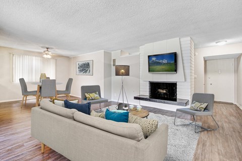 A living room with a grey couch and a fireplace.