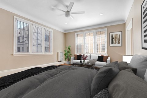 A bedroom with a large bed and a ceiling fan.