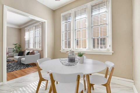 a dining room with a white table and chairs