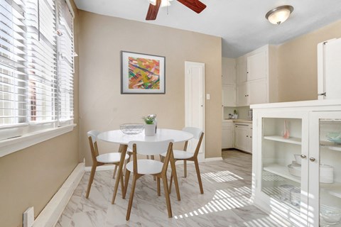 a dining room with a white table and chairs
