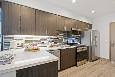 A modern kitchen with wooden cabinets and stainless steel appliances.
