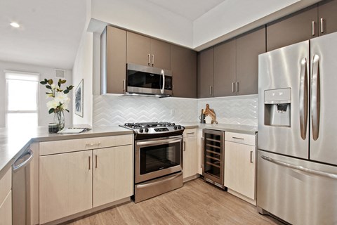 A modern kitchen with stainless steel appliances and wooden cabinets.