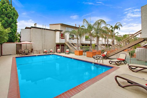 A swimming pool with a red border and a metal fence surrounding it.