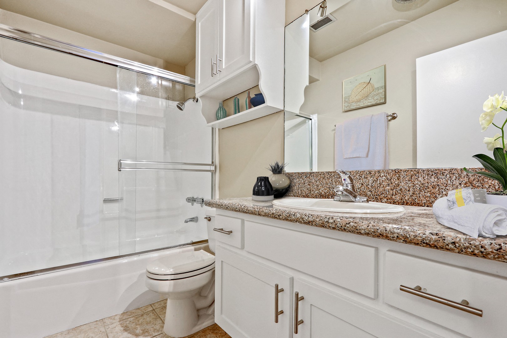 A white bathroom with a toilet, sink, and bathtub.