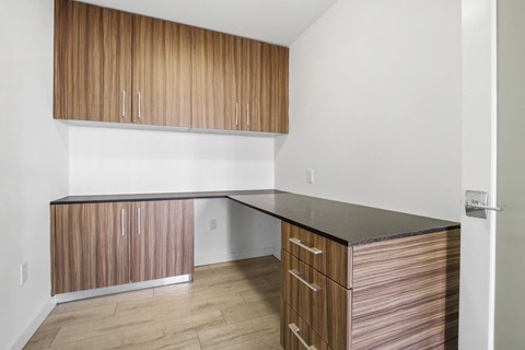 A kitchen with wooden cabinets and a black counter.