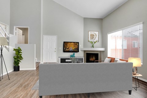 A living room with a grey couch and a fireplace.