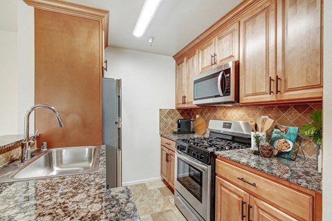 A kitchen with wooden cabinets and a granite countertop.