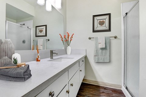 A bathroom with a white counter top and a grey towel.