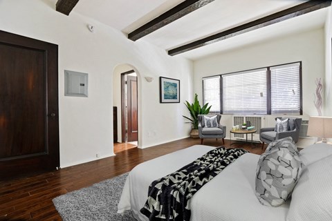 A bedroom with a large bed and a chair.