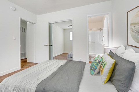 A bedroom with a bed and a painting on the wall.