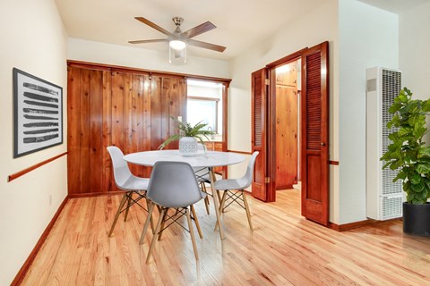 A dining room with a white table and chairs.