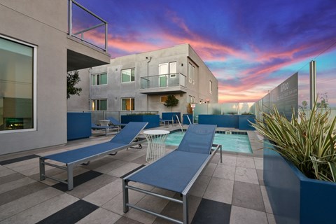 A modern house with a pool and lounge chairs.