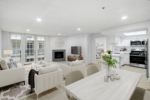 A modern living room with a white couch and a dining table.