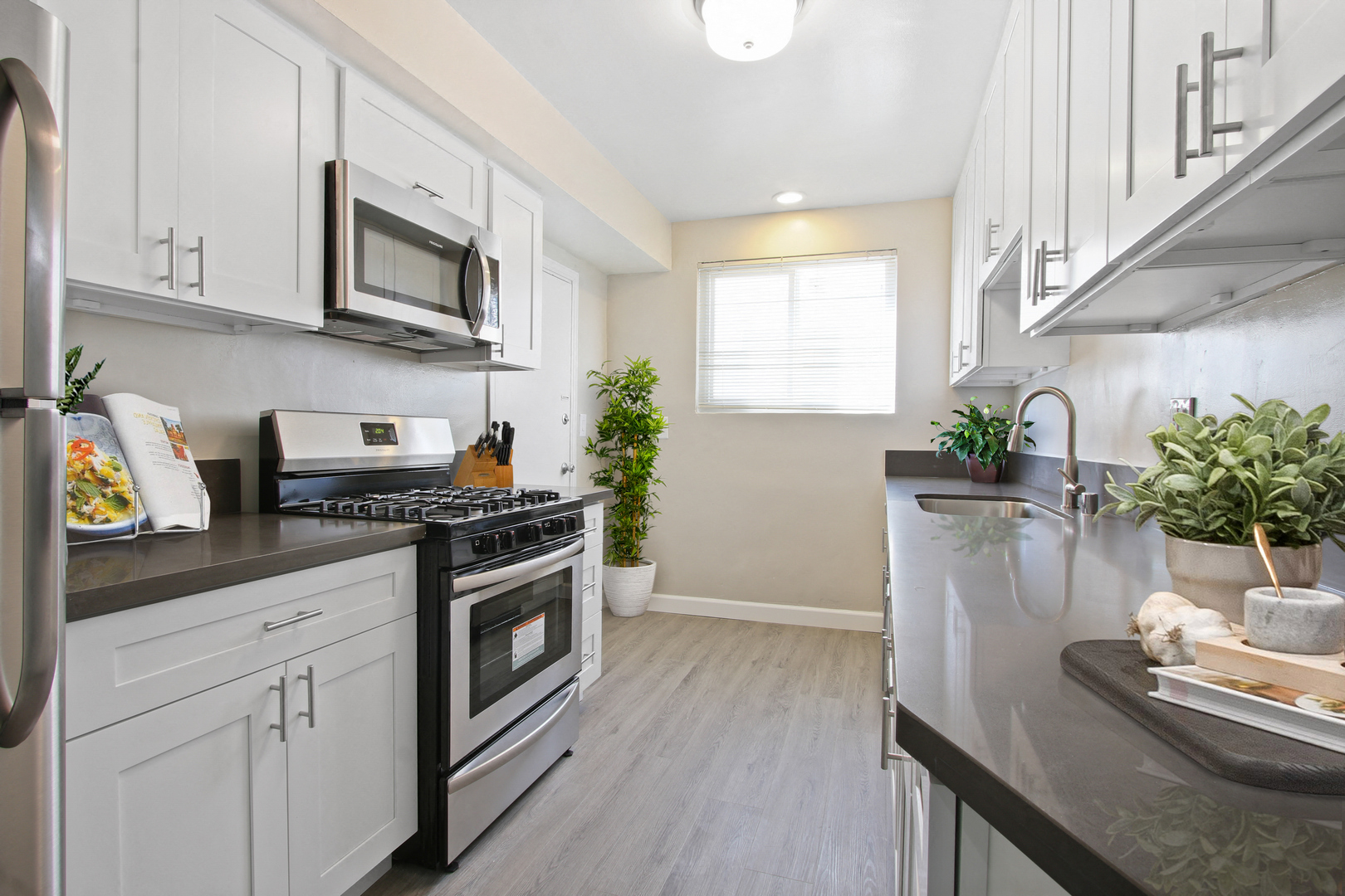 A modern kitchen with white cabinets and a black stove top.