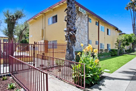 A yellow building with a red gate in front.