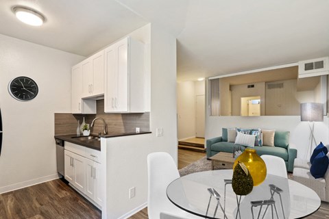 A modern kitchen with white cabinets and a wooden countertop.