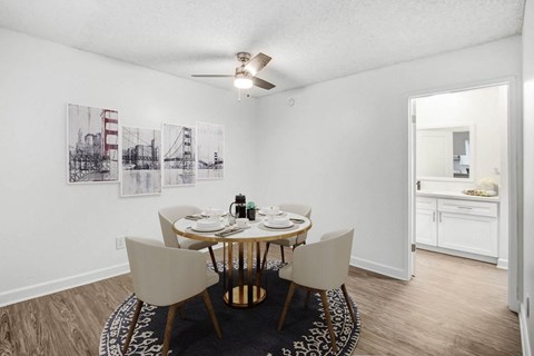 a dining room with a table and chairs and a ceiling fan