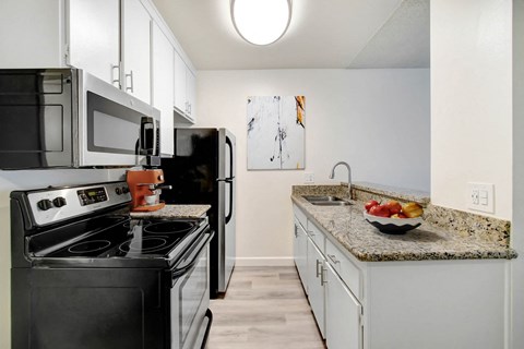 A kitchen with a black stove top oven and a black refrigerator.