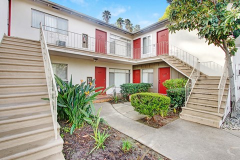 A building with red doors and a tree in front.