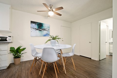 A dining room with a white table and chairs.