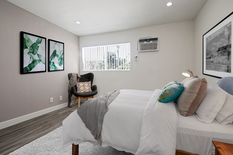 A bedroom with a large bed and a chair.