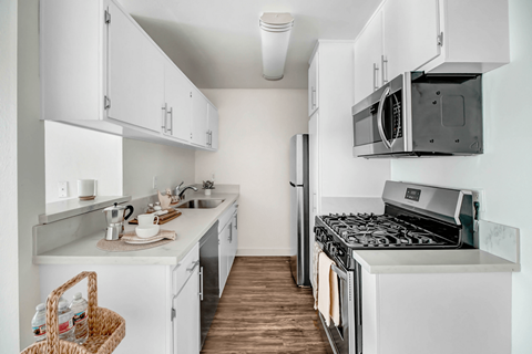 A white kitchen with a black stove top oven.