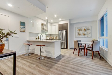 A modern kitchen with a dining table and chairs.