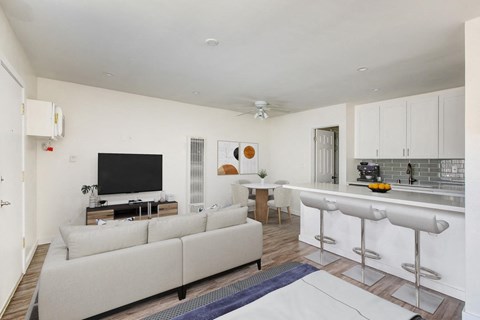 A modern living room with a white couch and a bar area.