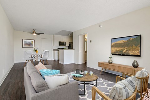 A living room with a grey couch and a painting on the wall.