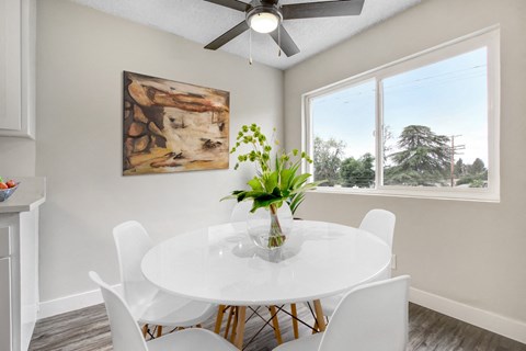 A dining room with a white table and chairs.
