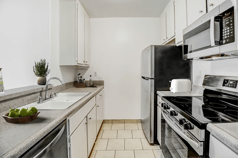 an all white kitchen with stainless steel appliances and a sink