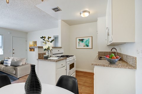 A kitchen with a table and chairs in the foreground.