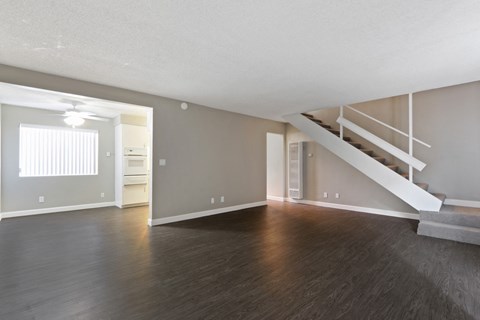 A spacious room with a staircase leading to another level.
