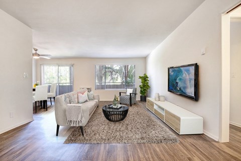 A living room with a couch, a coffee table, and a painting on the wall.