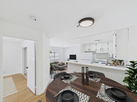 A modern dining room with a wooden table set for a meal.