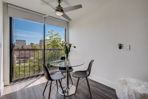 A dining room with a table and chairs and a ceiling fan.