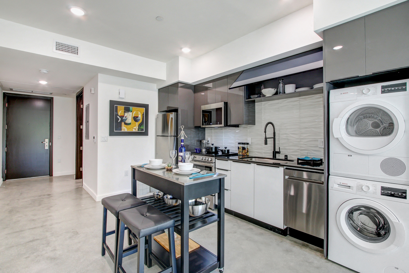 A modern kitchen with a washing machine and dishwasher built into the cabinetry.