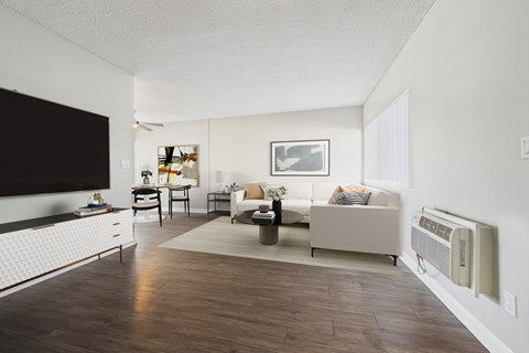 A living room with a white couch and a wooden floor.