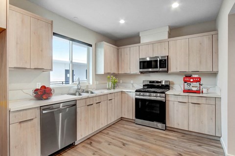 A modern kitchen with wooden cabinets and stainless steel appliances.