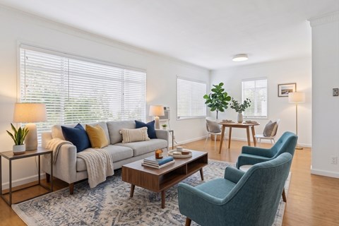 A living room with a grey couch, a blue chair, and a wooden coffee table.