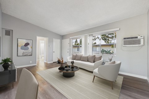 A living room with a grey sofa, a coffee table, and a painting on the wall.