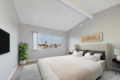 A bedroom with a large bed and a flat screen TV mounted on the wall.