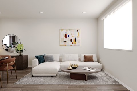 A living room with a white couch, a brown coffee table, and a painting on the wall.