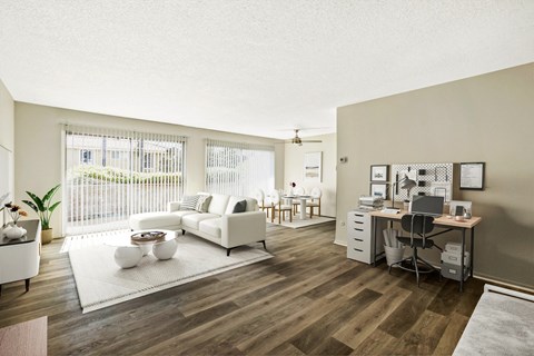 A living room with a white couch and a wooden floor.