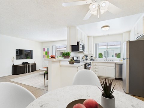 A modern kitchen with a dining table and chairs in the foreground.