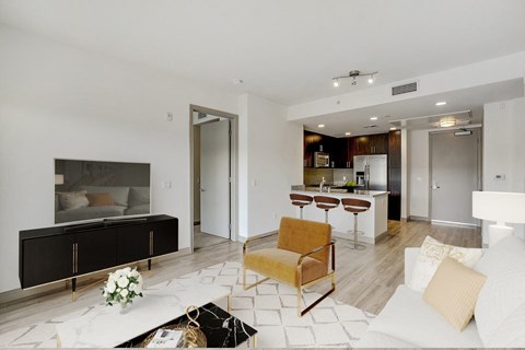 A modern living room with a yellow chair and a black and white rug.