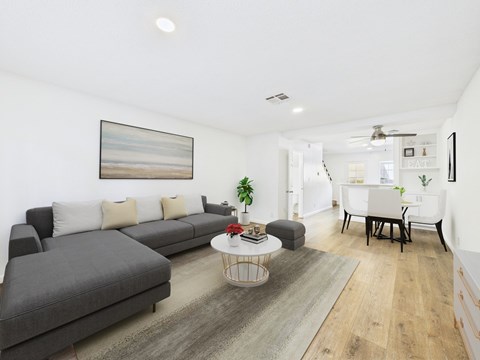 A living room with a grey sofa, a white coffee table, and a painting on the wall.