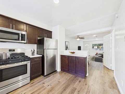 A kitchen with a stove top oven and a refrigerator.