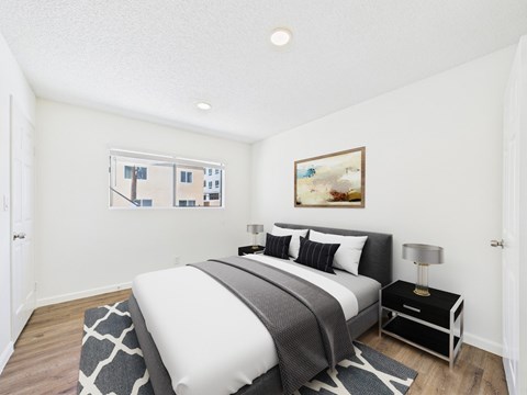 A bedroom with a large bed and a painting on the wall.