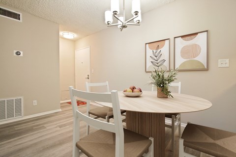 A dining room with a round table and chairs.